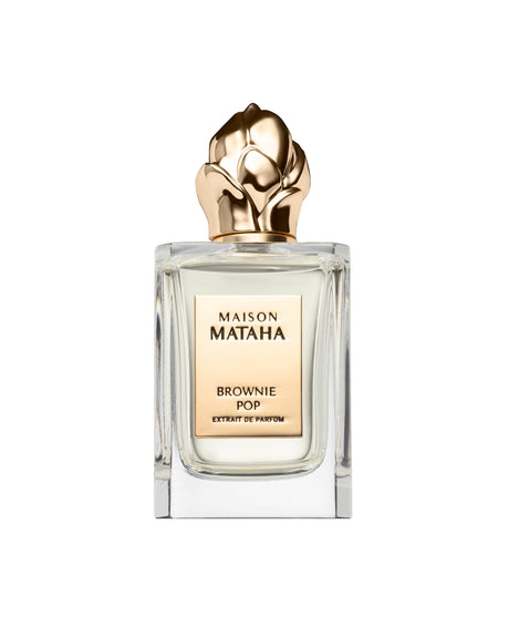 The Brownie Pop Extrait de Parfum by Maison Mataha features a clear glass bottle with a gold rose-shaped cap against a white background, suggesting a gourmet aroma reminiscent of brownies.