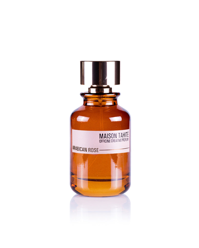 A brown glass bottle with a shiny silver cap labeled "Arabican Rose Eau de Parfum - Maison Tahite" by Maison Tahite, an oriental luxury fragrance, is photographed against a plain white background.