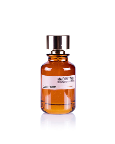 The Maison Tahite Coffee Bomb Eau de Parfum, in a brown glass bottle with a metallic cap, features rich Italian coffee and amber notes, presented against a white background.