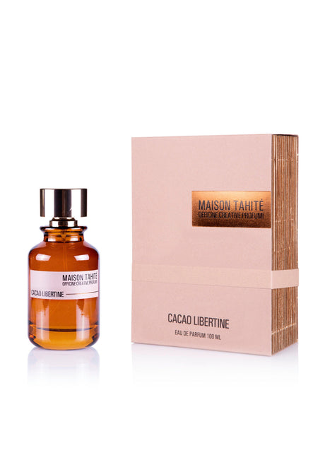 A brown glass bottle with black cap labeled Maison Tahite stands beside a beige box with orange accents, presenting Cacao Libertine Eau de Parfum—a gourmand scent perfect for fans of vanilla and patchouli.