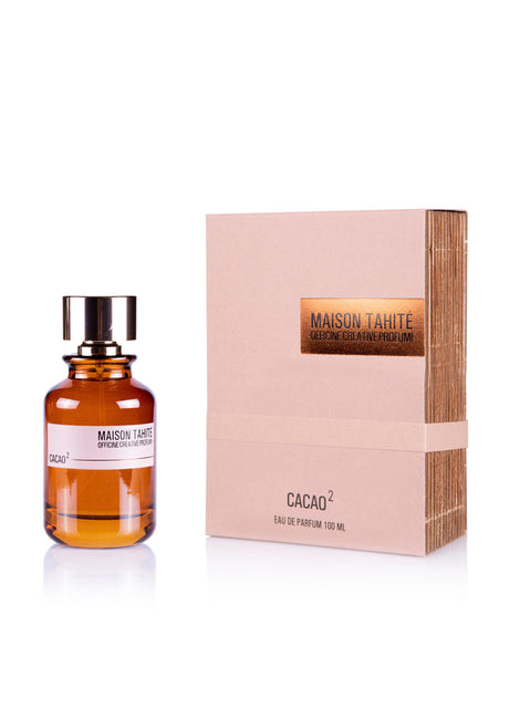 A brown glass bottle of Maison Tahite Cacao 2 Eau de Parfum with a black cap and white label stands by its beige box with gold accents, both showing the Maison Tahite brand and Cacao 2 fragrance name.