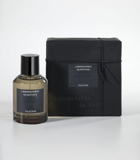 A bottle of Laboratorio Olfattivo ExplOud Eau de Parfum, known for its rich oud scent, stands beside a matching black box with branded labels, both arranged against a white background.