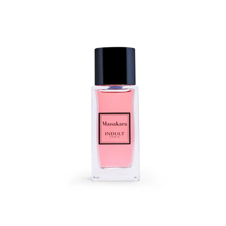 A clear glass bottle with pink liquid and a black cap, labeled Manakara Eau de Parfum - Indult by Fragrapedia Haus, sits against a white background—a lychee fragrance blending delicate fruit notes with Damascena rose.