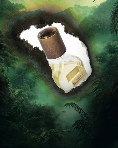 A glass perfume bottle with a bronze cap and gold RISVELIUM label stands against a torn white backdrop over lush green jungle—Fragrapedia Haus’s Risvelium Eau de Parfum by Orto Parisi, an ethereal scent capturing nature’s awakening.