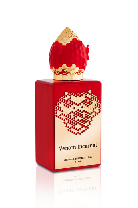 A red Venom Incarnat Eau de Parfum bottle by Fragrapedia Haus features a gold label with honeycomb design and a gold-red cap, evoking the allure of a love potion.