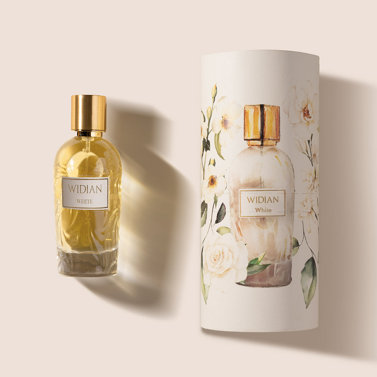 A bottle of White Eau de Parfum by Fragrapedia Haus, featuring a gold cap, stands beside its cylindrical box adorned with a watercolor floral design, reflecting the fragrance’s floral bouquet and precious woods musk.