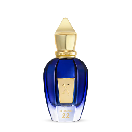 A blue glass perfume bottle with a gold cap and label embossed with TORINO22 on the front, inspired by professional tennis, from Fragrapedia Haus. Product: Torino 22 Eau de Parfum - Xerjoff. Set against a plain white background.