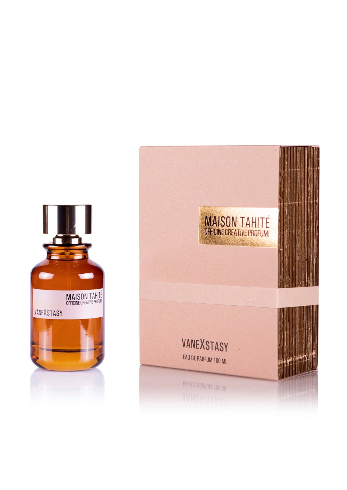 A 100 ml brown glass bottle of Maison Tahite Vanexstasy Eau de Parfum, featuring vanilla absolute, sits beside a matching beige and gold box. The bottle has a shiny silver cap and displays the Maison Tahite brand.