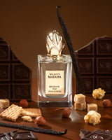 Brownie Pop Extrait de Parfum by Maison Mataha is pictured with chocolate squares, sugar cubes, vanilla beans, hazelnuts, biscuits, and caramelized popcorn—an irresistible gourmet scent for brownie fragrance lovers.