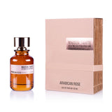 A Maison Tahite Arabican Rose Eau de Parfum 100ml bottle, in brown glass with a gold cap, sits next to its beige, metallic-accented box. The packaging reflects the fragrance’s exquisite, oriental-inspired luxury.