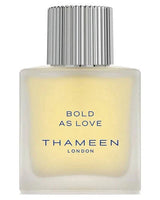 A bottle of Bold As Love Eau de Cologne by Fragrapedia Haus features a frosted rectangular glass design, tall silver ridged cap, and bold blue text—embodying the smoky leather essence in every detail.