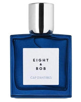 A blue glass bottle of Cap d'Antibes Eau de Parfum by Fragrapedia Haus, featuring a silver cap and white label with black lettering—a perfect luxury fragrance for summer.