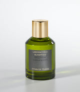A green glass bottle of Laboratorio Olfattivo’s Arancia Rossa Eau de Parfum, featuring a gold cap and vibrant mandarin and bergamot notes, is set against a plain light gray background.