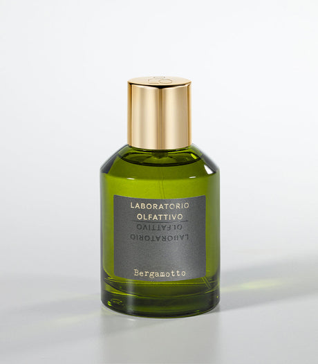 A green glass bottle of Laboratorio Olfattivo’s Bergamotto Eau de Parfum with a gold cap stands against a light gray background, capturing Italian elegance and the refreshing essence of bergamot.