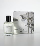 A bottle of Decou Vert Eau de Parfum by Laboratorio Olfattivo stands beside its floral-patterned box labeled "Laboratorio in Fiore." The scent combines vibrant florals with musky, woody notes; the bottle has a black cap and clear liquid.