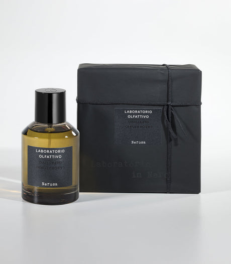 A bottle of Nerosa Eau de Parfum by Laboratorio Olfattivo stands beside its sleek black packaging, both displaying minimalist black and white labels on a white background—an elegant presentation for this saffron-scented fragrance.