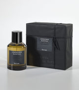 A bottle of Nerosa Eau de Parfum by Laboratorio Olfattivo, made with natural raw materials, sits beside its matching black packaging on a light gray background.