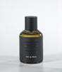 A bottle of Oud in White Eau de Parfum by Fragrapedia Haus, featuring a black cylindrical cap and textured dark gray label against a light background—an elegant floral fragrance with soft sandalwood notes.