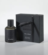A black bottle of Oud in White Eau de Parfum by Fragrapedia Haus stands beside a matching ribbon-tied box, both with embossed labels—hinting at the floral blend of jasmine, oud, and sandalwood within.