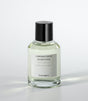 A clear glass bottle of Cozumel Eau de Parfum by Laboratorio Olfattivo, featuring a black cap and minimalist white label, is set against a light background, reflecting the aromatic essence of this signature fragrance.