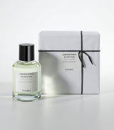 A clear glass bottle of Cozumel Eau de Parfum by Laboratorio Olfattivo, an aromatic men's fragrance, stands beside a white box tied with black string and featuring the matching Laboratorio Olfattivo label.
