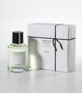 A clear bottle of Cozumel Eau de Parfum by Laboratorio Olfattivo stands beside a white gift box wrapped with black string and a matching label, both set against a plain white background.