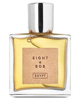 A clear glass bottle with yellow perfume and a silver cap features a tan label reading EIGHT & BOB EGYPT, by Fragrapedia Haus. The Egypt Eau de Parfum hints at an exotic scent inspired by ancient Egyptian perfumery.