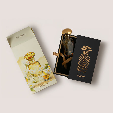 Samar Extrait de Parfum by Fragrapedia Haus features a luxury bottle with a gold cap in a black gift box with a gold palm, beside an illustrated outer box of white flowers and gold bottle—hinting at patchouli notes.