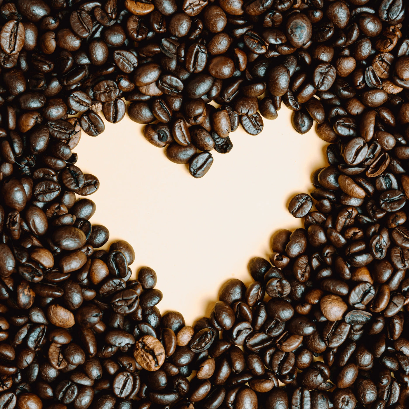 Heart shape made of coffee beans on a wooden surface