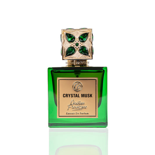 A green colored perfume bottle with a decorative cap featuring emerald stones, labeled 'CRYSTAL MUSK EDP'.