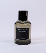 A clear glass bottle with a black cap and label reading "Laboratorio Olfattivo ExplOud Eau de Parfum" rests on a white background, emphasizing this woody, luxurious oud fragrance from Laboratorio Olfattivo.