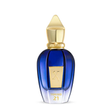 Torino 21 Eau de Parfum by Fragrapedia Haus features a blue and gold bottle with a pointed cap, gold label, and TORINO21 on the front—a luxurious design inspired by the vibrant energy of professional tennis.