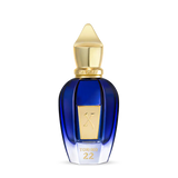 A blue glass perfume bottle with a gold cap and label embossed with TORINO22 on the front, inspired by professional tennis, from Fragrapedia Haus. Product: Torino 22 Eau de Parfum - Xerjoff. Set against a plain white background.