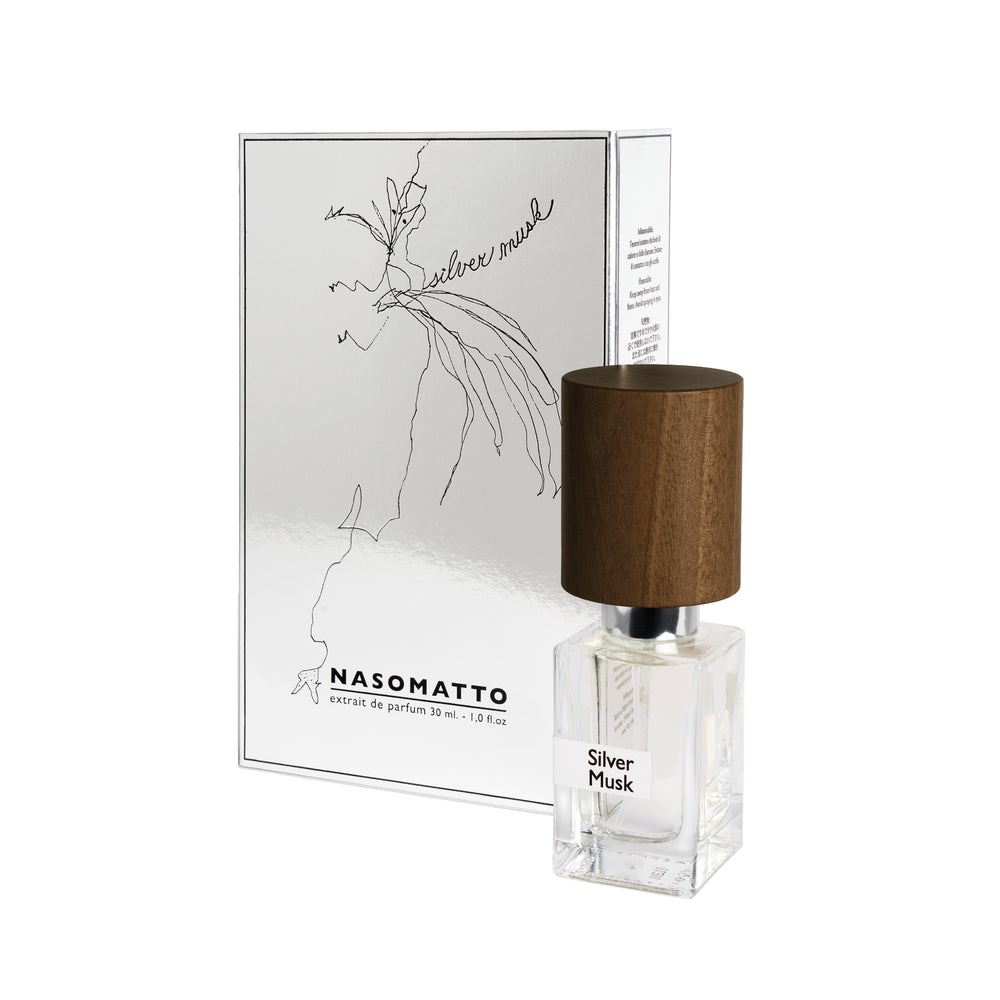 A clear glass bottle of Fragrapedia Haus Silver Musk Extrait de Parfum with a wooden cap stands before its matching white and silver box, which displays minimalist line art and the fragrance’s name.